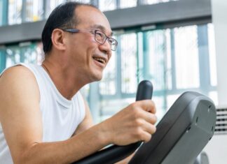 Mayo Clinic Minute: Aging and the benefits of exercising a middle aged Asian man wearing glasses and smiling while running and exercising on a treadmill