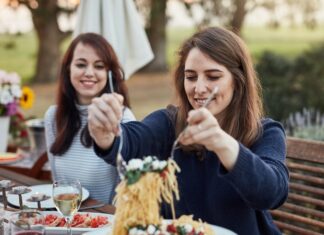 How to eat carbs without spiking your blood sugar, according to a nutrition researcher Two women enjoying a pasta dinner outdoors