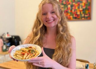 I Asked ChatGPT to Prepare a Healthy Meal Plan for the Week. Here’s How It Went blonde woman holding a pasta dish and smiling in her kitchen