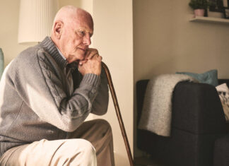 Report: Older adults in poor physical, mental health more apt to feel lonely, isolated Image of older man with cane, sitting alone