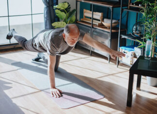 UBCO celebrates Embrace Aging Month An elderly man practices a yoga pose in a sunny studio.