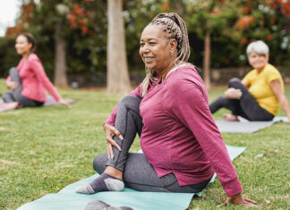 Socioeconomic advantages slow aging process at cellular level, study funds Multiracial women doing yoga exercise with social distance for coronavirus outbreak at park outdoor - Healthy lifestyle and sport concept