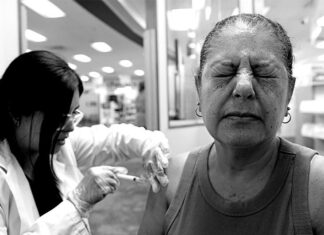 Shingles vaccine may lower heart disease risk by up to 8 years An odler adult woman gets vaccinated against shingles by a healthcare professional