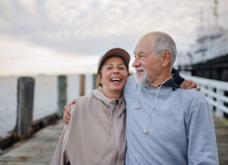 How CVS Health supports heart health prevention and care A couple enjoying a brisk walk on a pier, promoting a heart-healthy lifestyle